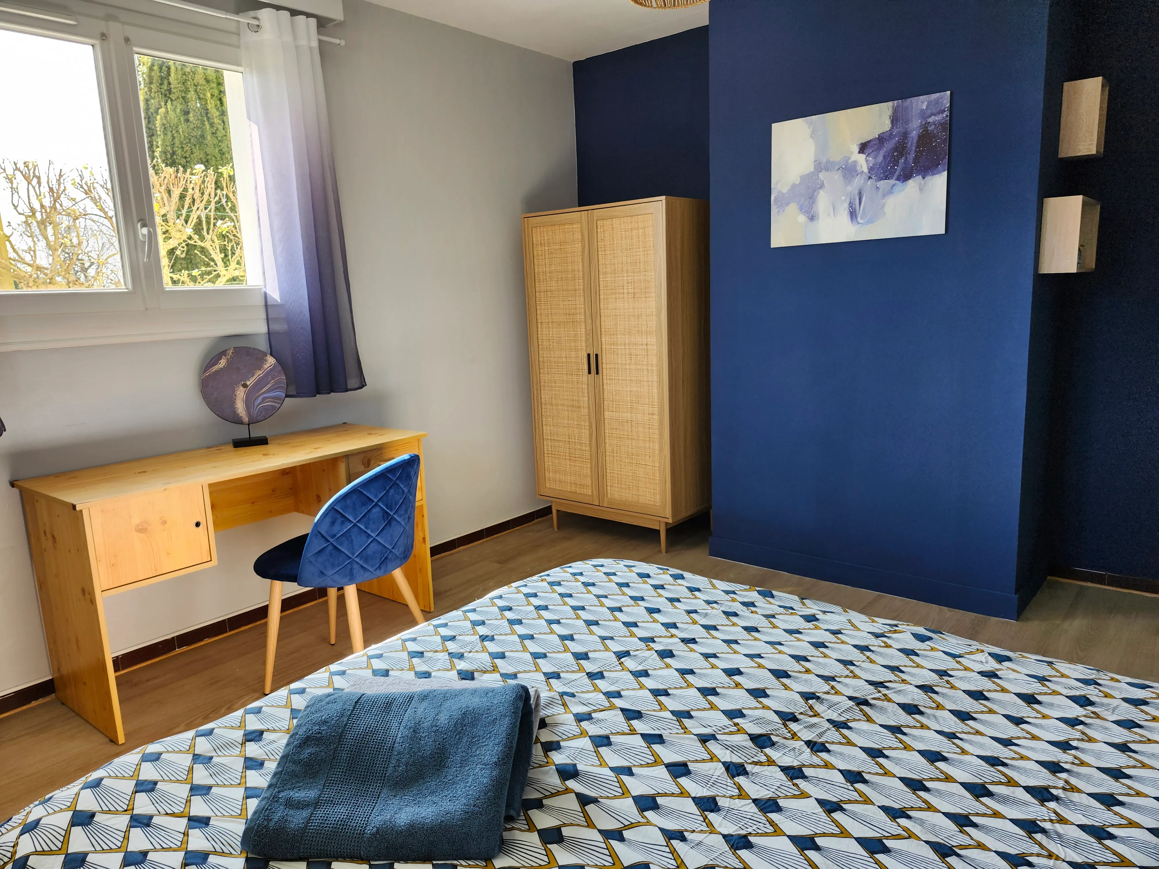 Chambre Bleu navy : mur bleu navy, armoire en cannage et bureau