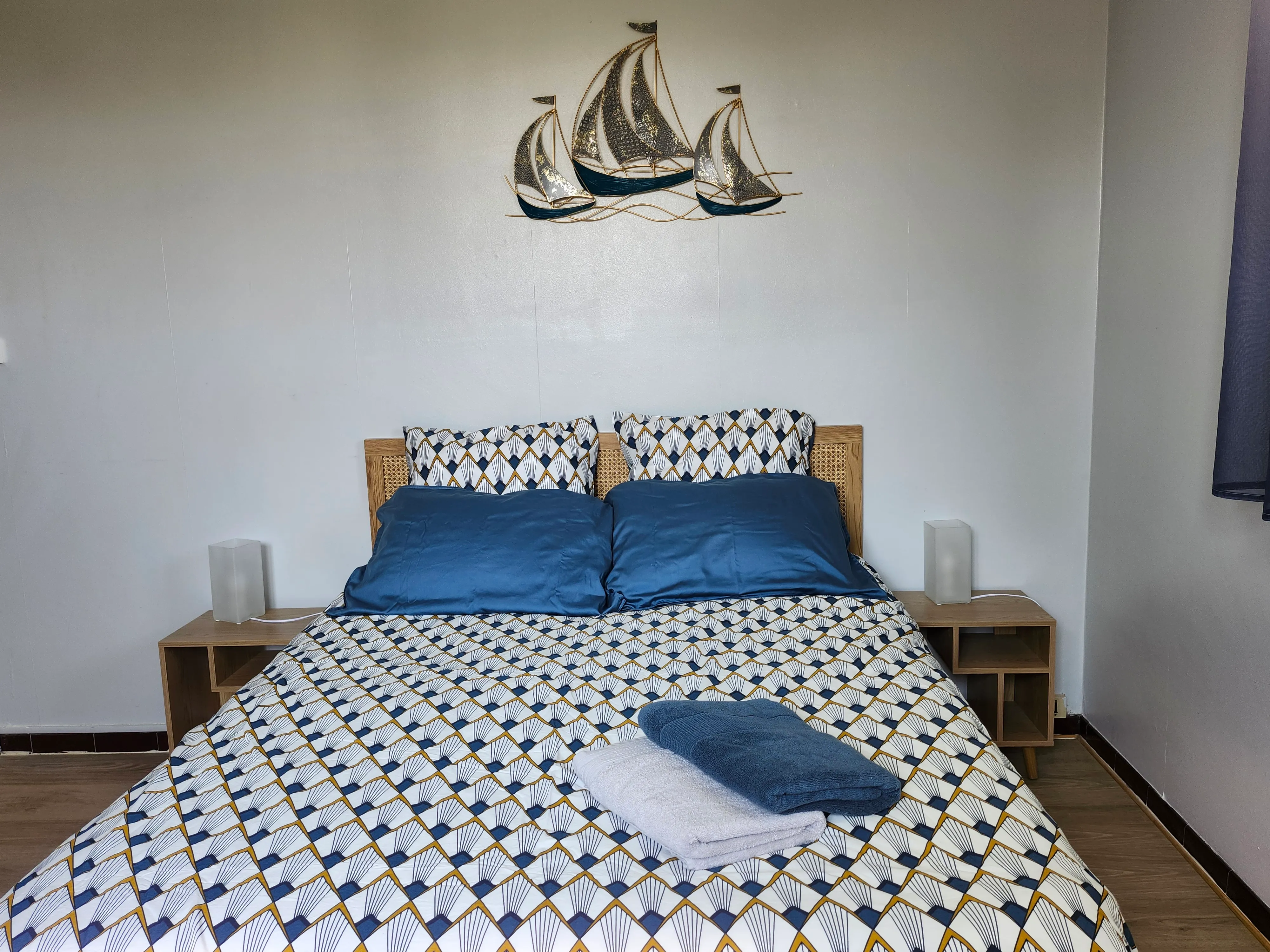 Chambre Bleu navy : lit double, parure Art déco et voiliers dorés