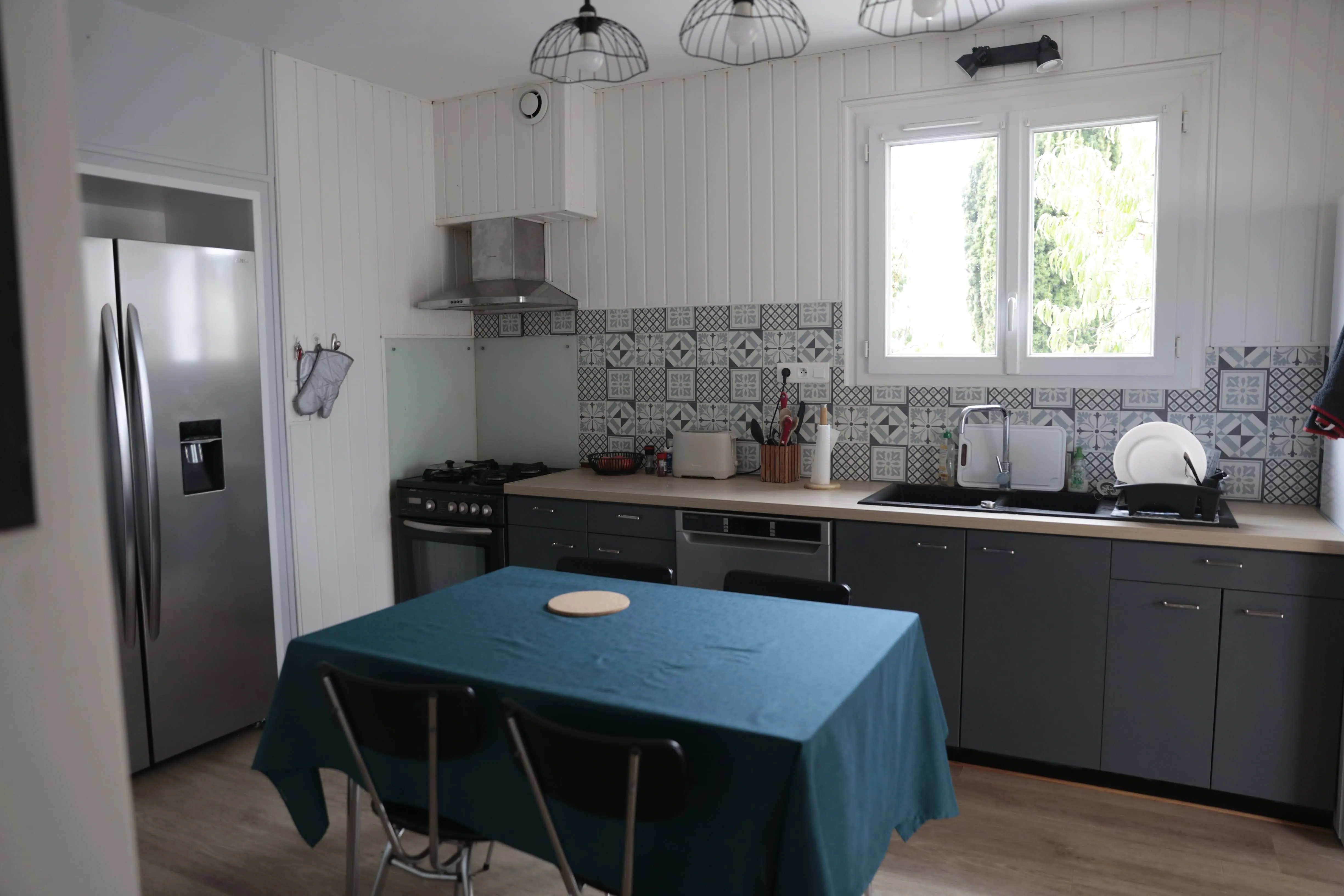 Cuisine équipée du gîte de Mellonia : réfrigérateur américain, cuisinière et carreaux de ciment
