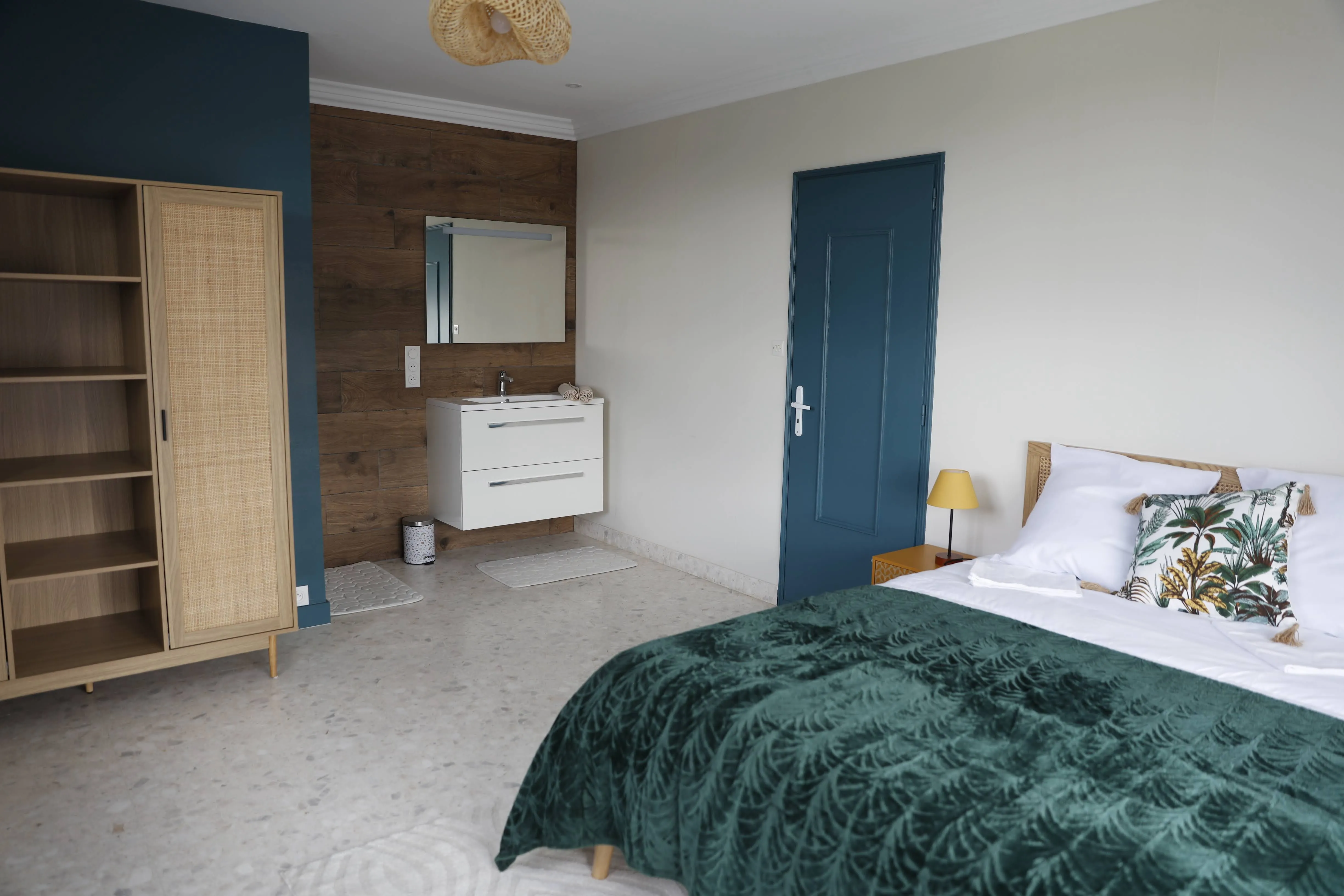 Chambre Céladon : salle de bain privative avec meuble vasque, armoire en cannage et lit double